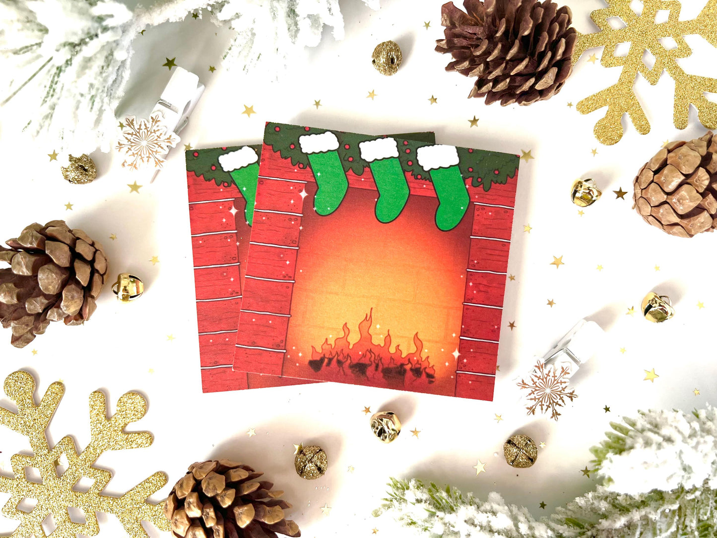Holiday themed sticky notes of a red bricked fireplace, green hung stockings and green garland on top, with a log fire lit at the bottom.