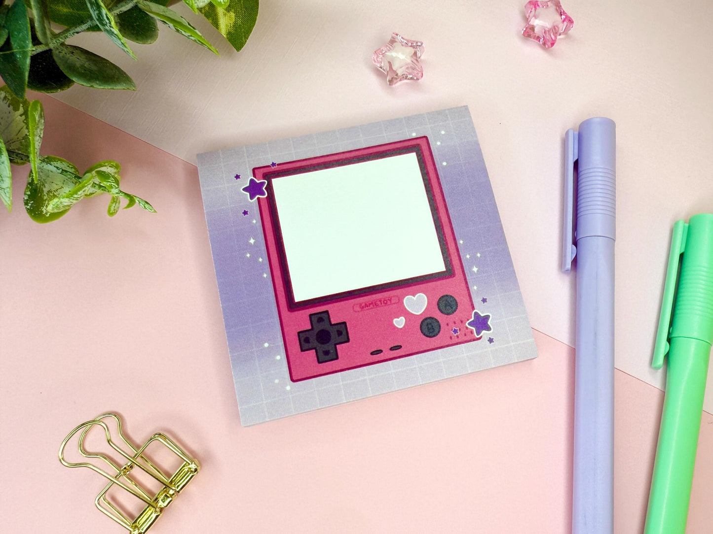 Pink game toy console with a purple background.