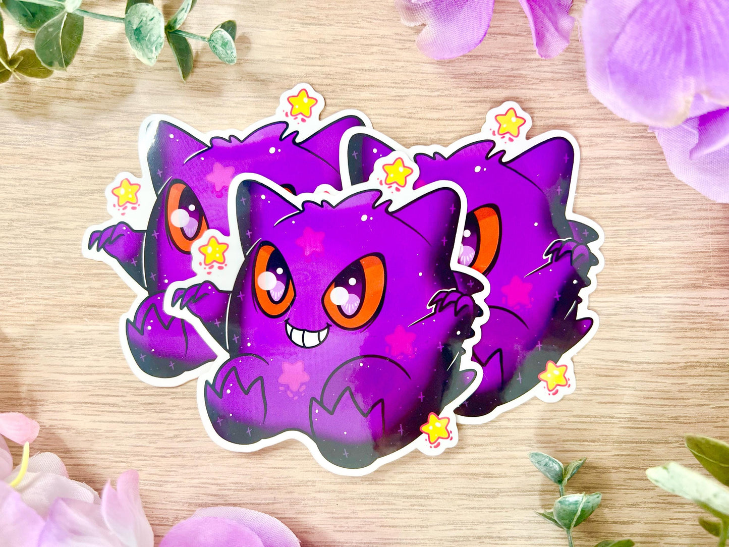 Purple and black ghost design with large eyes and yellow stars.