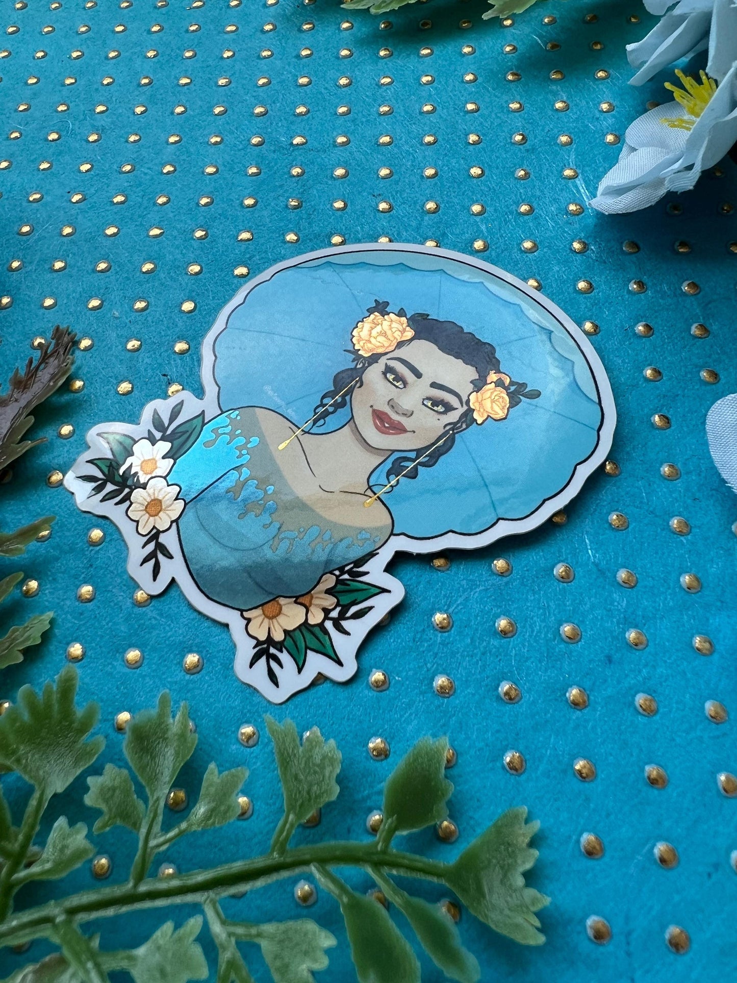 Sticker of a beautiful girl with curled hair, orange roses in her hair, wearing a blue blouse and blue umbrella behind her with white and yellow flowers and green leaves on the bottom of her upper torso.