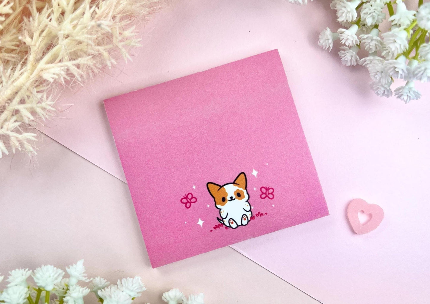 Sticky note with a dog illustration on a pink background surrounded by butterflies