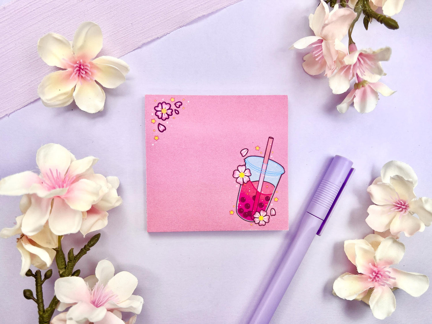 Pink sticky note with and illustration of pink boba milk tea surrounded by pink flowers and yellow stars.