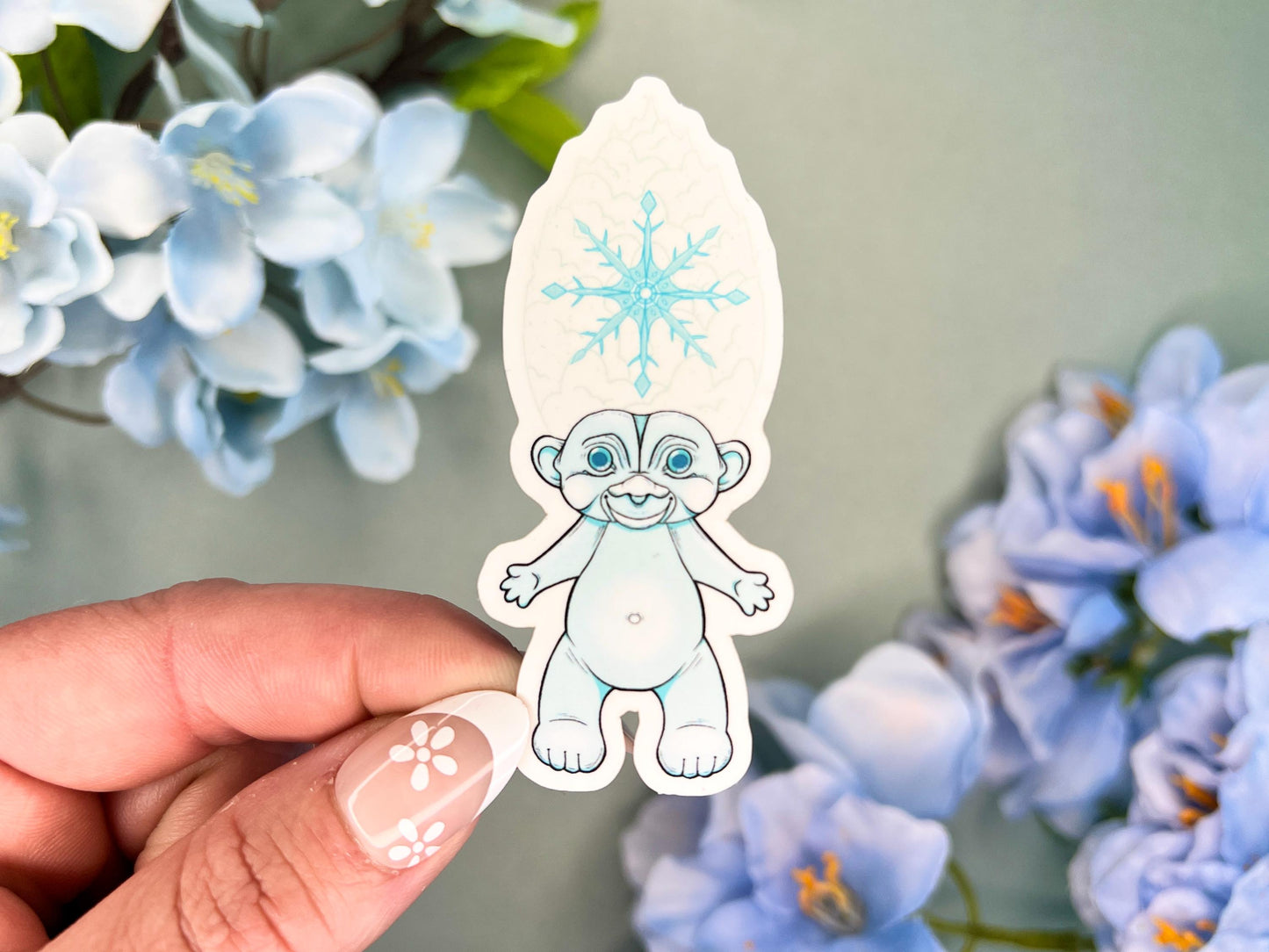 Retro Hair Creature sticker with icy blue hair and a snowflake base, around 3 inches tall.