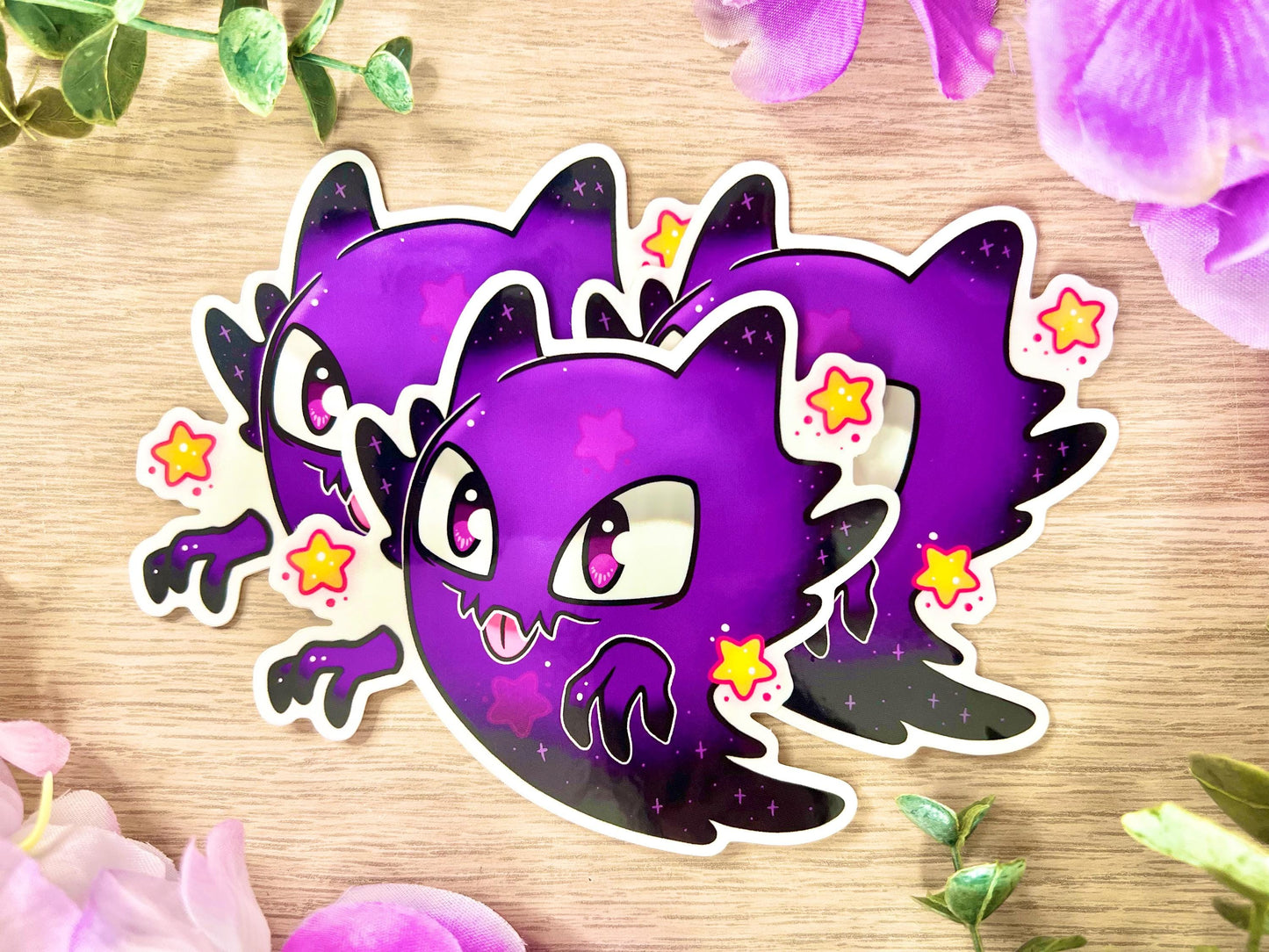 Cute purple and black horned ghost with big eyes surrounded by yellow stars.