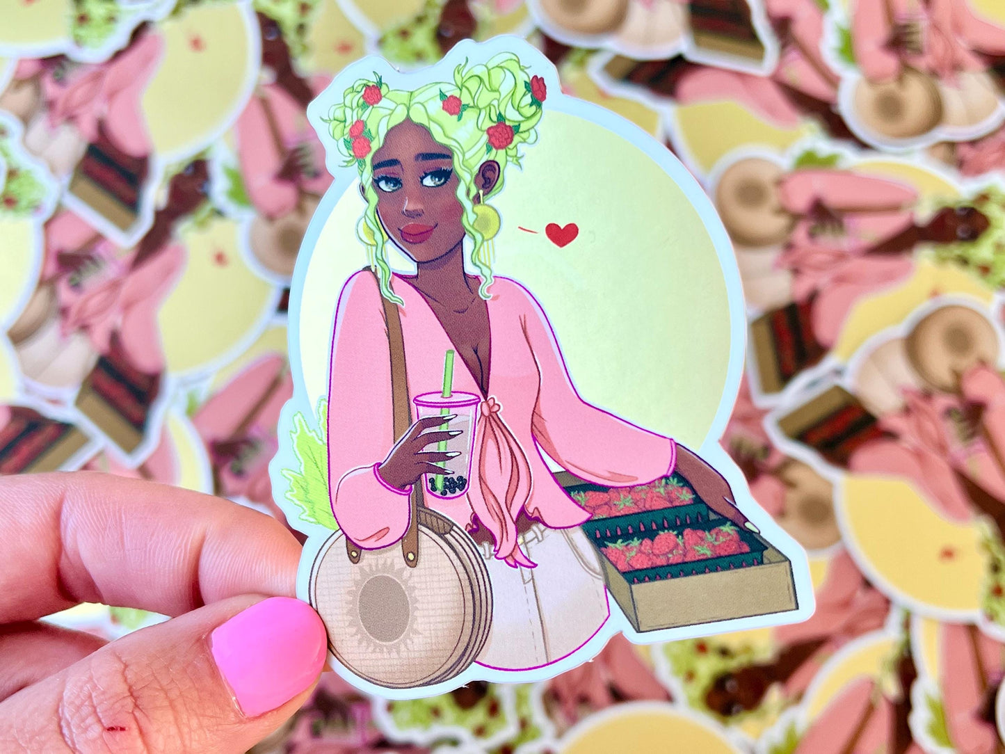 Sticker of a cute girl with green hair and red flowers in it, holding a milk tea drink in one hand and strawberries in the other placed in front of a golden sun background.