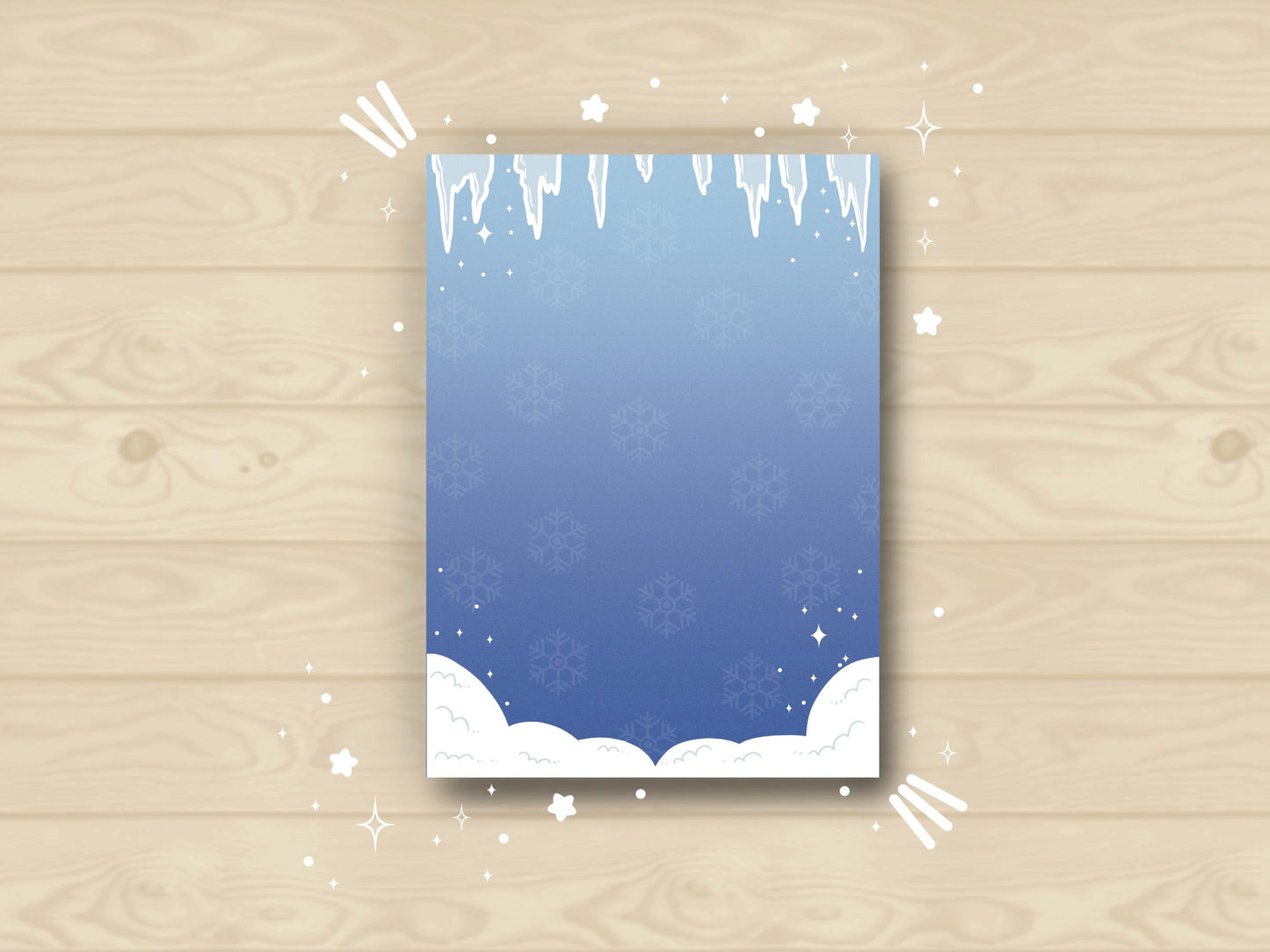 A blue notepad with white icicles bordering the top, white snow bordering the bottom, and a white snowflake pattern in the background.