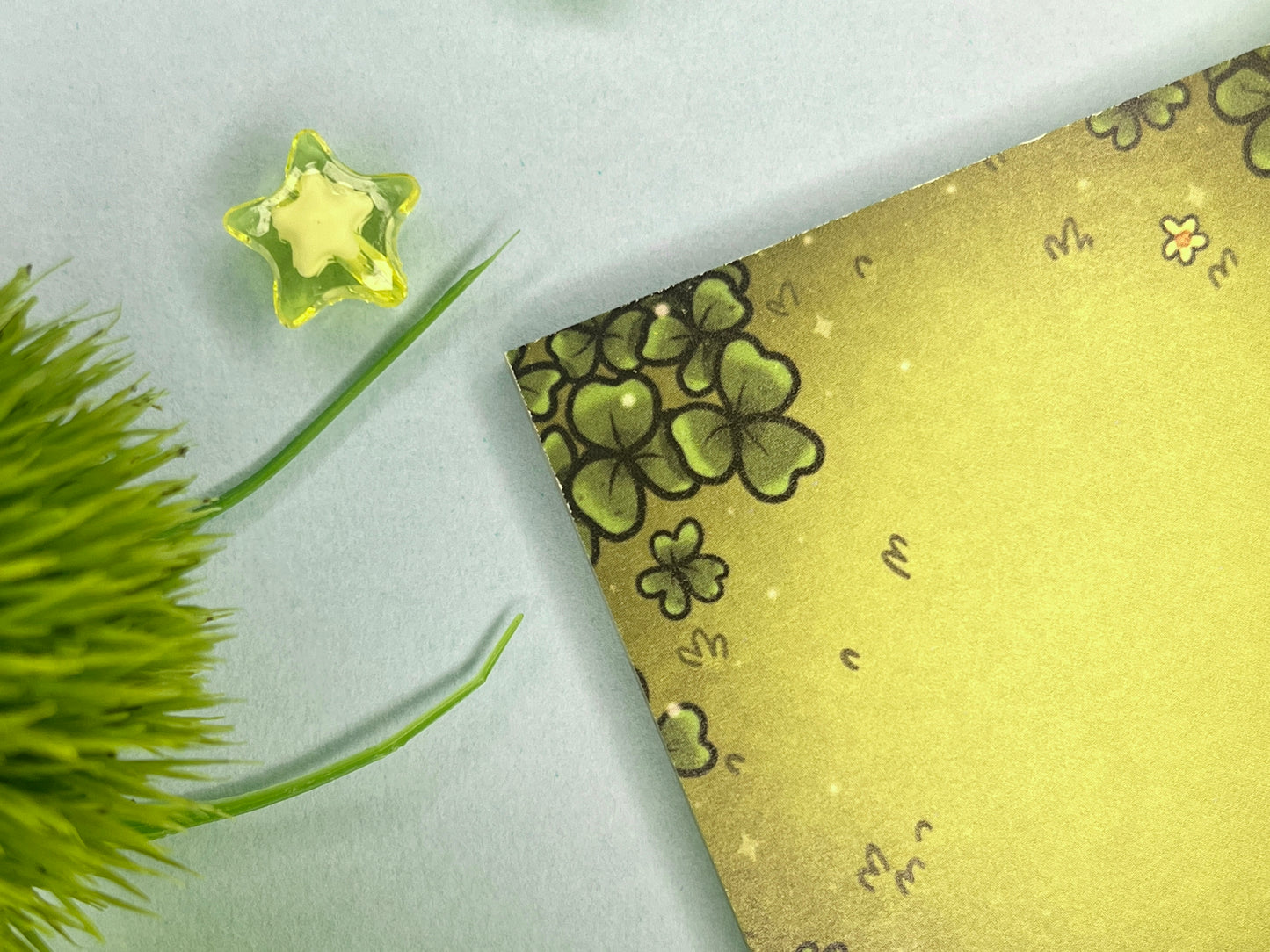 Green sticky notes of a field of green clovers, grass, and yellow flowers.