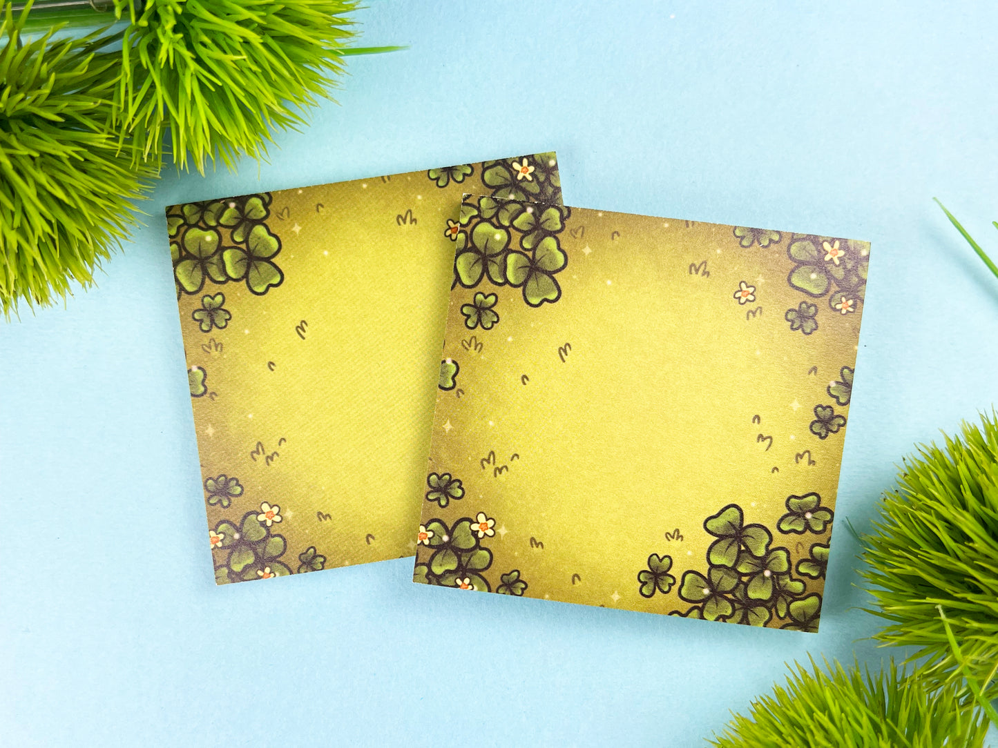 Green sticky notes of a field of green clovers, grass, and yellow flowers.