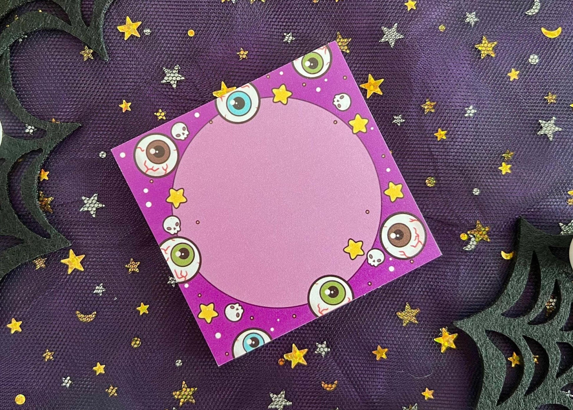 Purple background sticky notes with different colored eyeballs, skulls, and yellow stars surrounding a circle in the middle.
