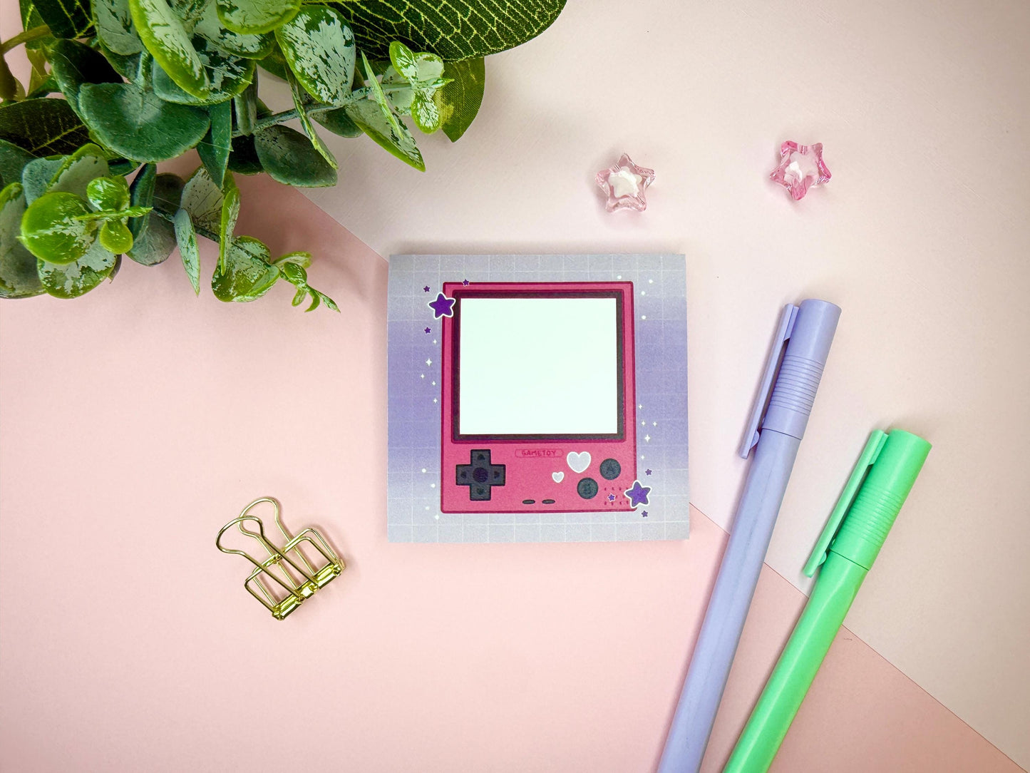 Pink game toy console with a purple background.