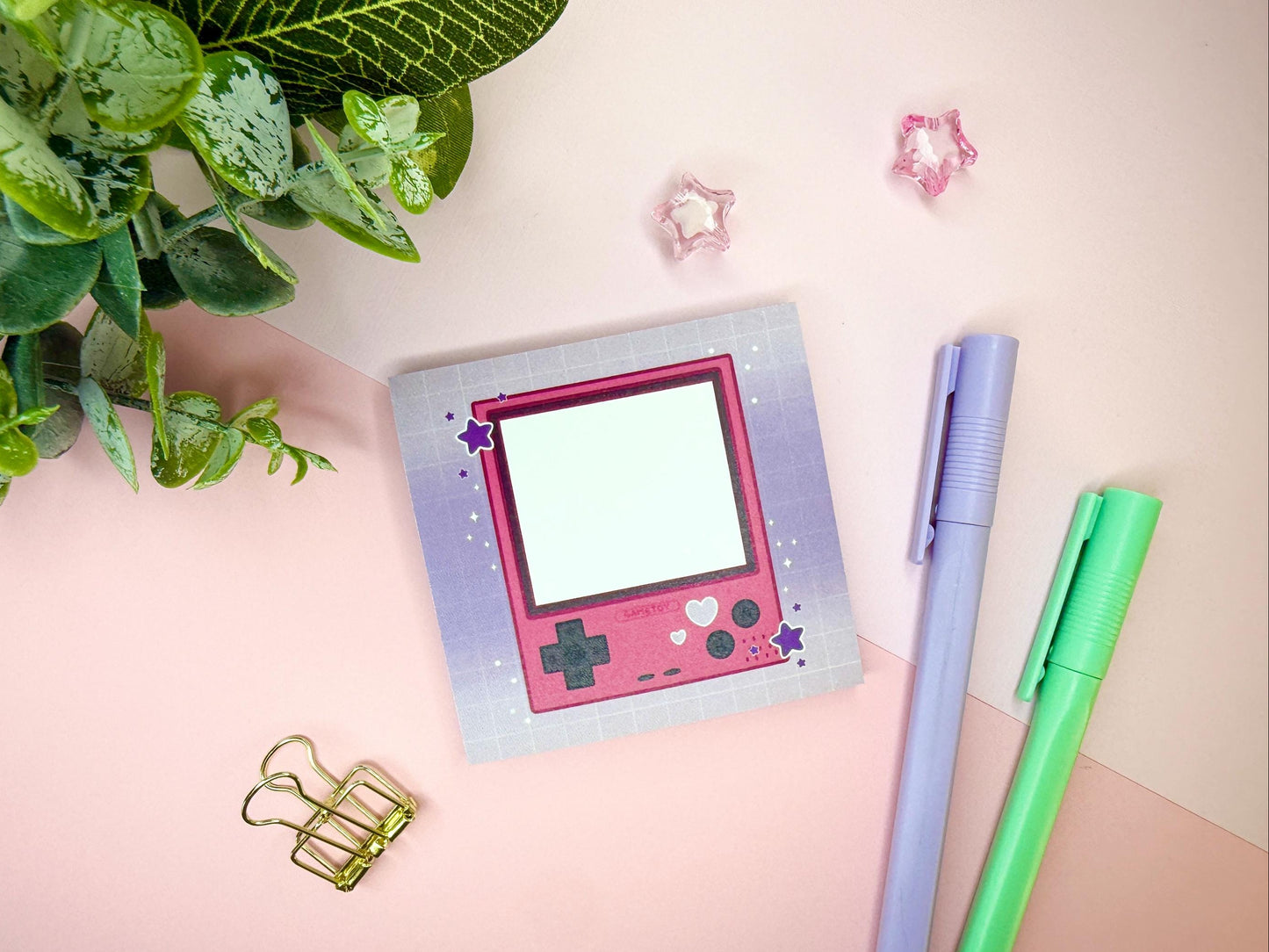 Pink game toy console with a purple background.