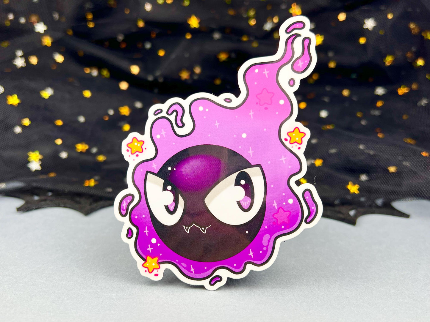 Purple and black ghost cloud design with large eyes and sparkles.