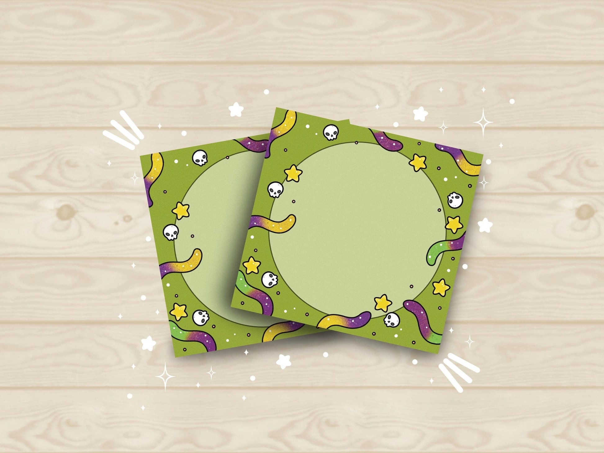 Green background sticky notes with purple and yellow and purple and green gummy worms, skulls, and yellow stars surrounding a circle in the middle.