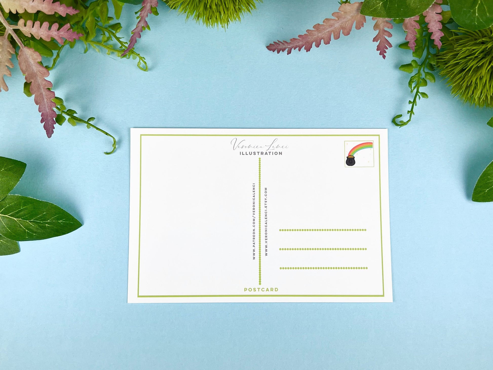 Back of the postcard with a line down the middle, lines on the right side for and address, and a cute pot of gold with a rainbow illustration where the stamp would go. 