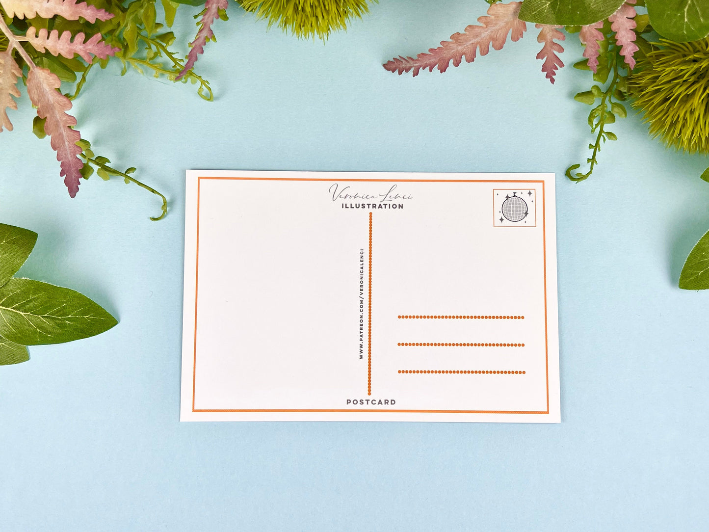 Back of the postcard with a line down the middle, lines on the right side for and address, and a cute disco ball illustration where the stamp would go. 