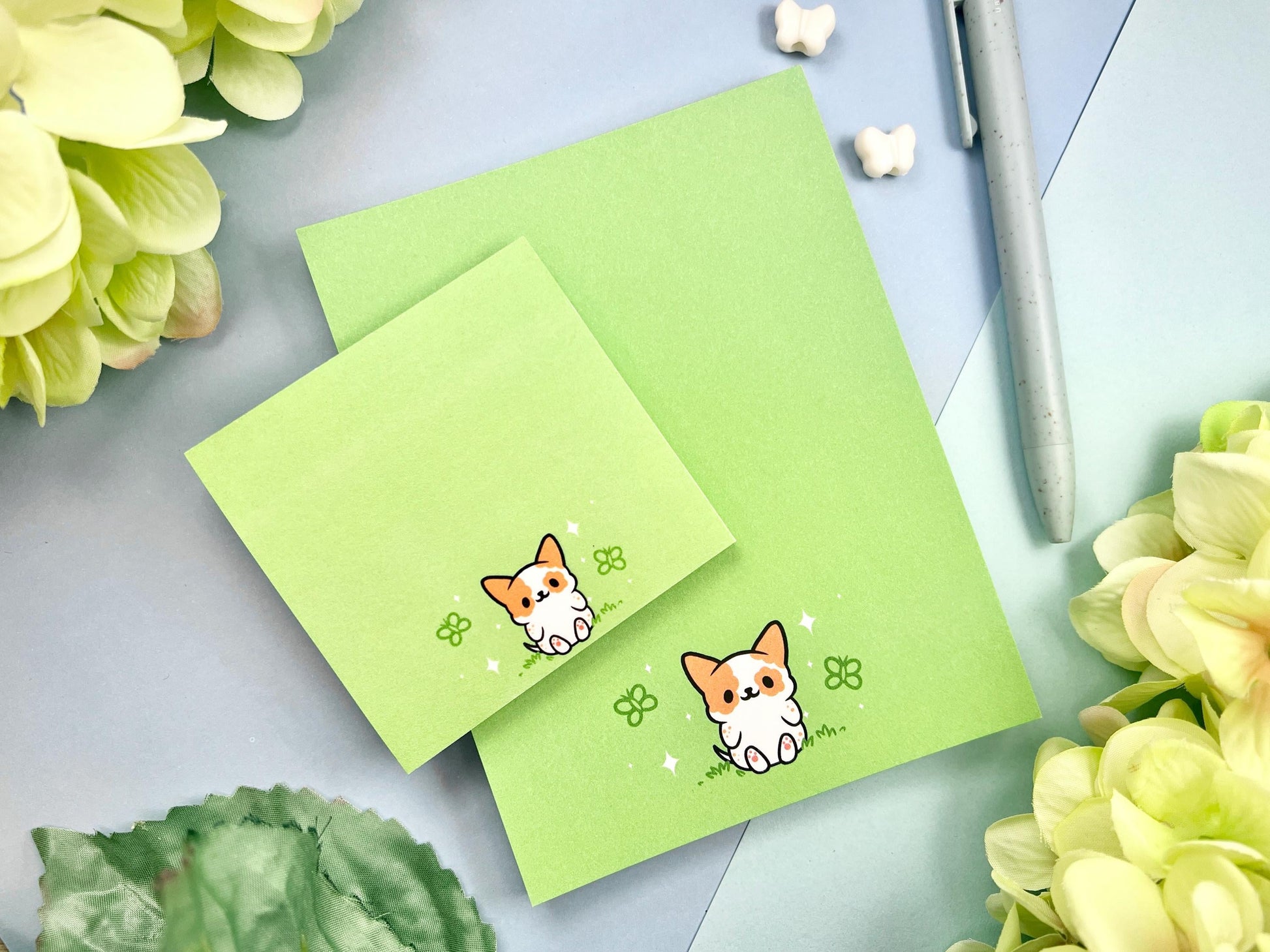 A sticky note and notepad gift set with a dog illustration on a green background surrounded by butterflies.
