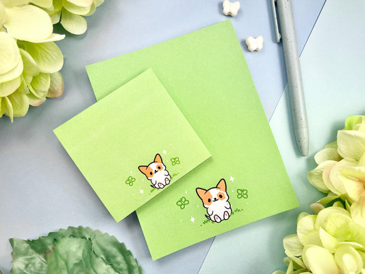 A sticky note and notepad gift set with a dog illustration on a green background surrounded by butterflies.