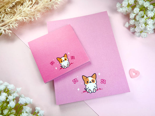 A sticky note and notepad gift set with a dog illustration on a pink background surrounded by butterflies.