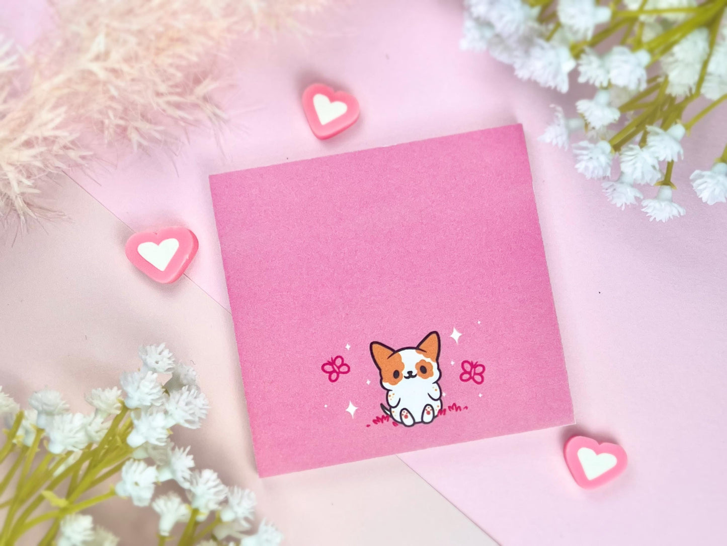 Sticky note with a dog illustration on a pink background surrounded by butterflies