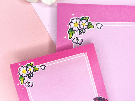 A pink gift set, including sticky notes and a notepad, that has an illustration of a cute dog wearing a pink kimono holding an umbrella under cherry blossoms. 