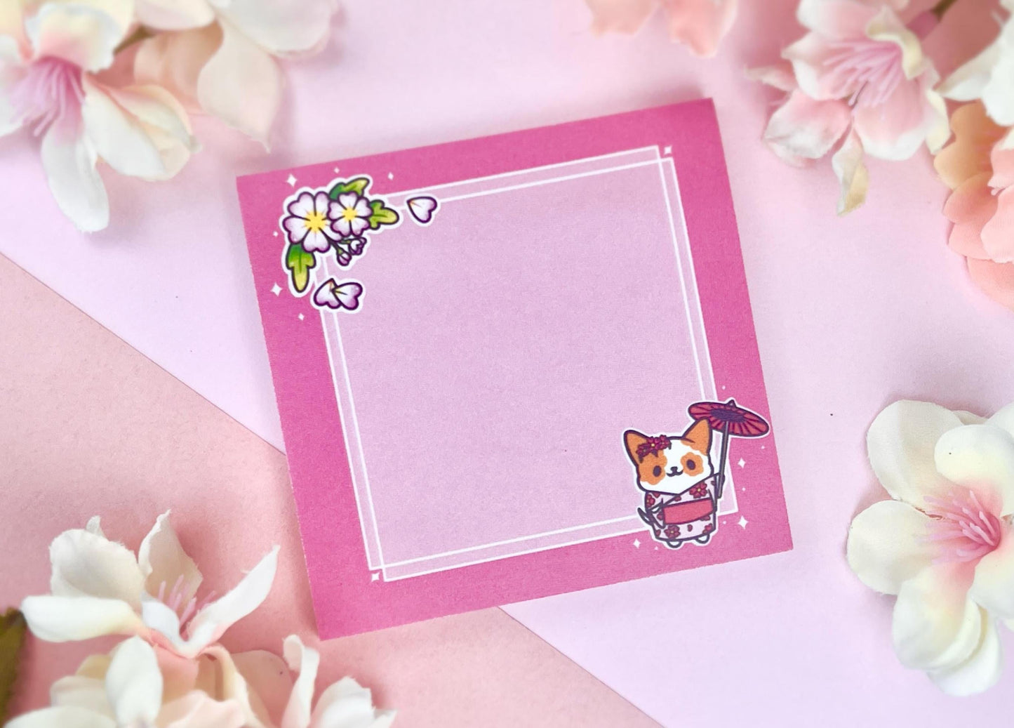 Pink sticky notes that have an illustration of a cute dog wearing a pink kimono holding an umbrella under cherry blossoms. 