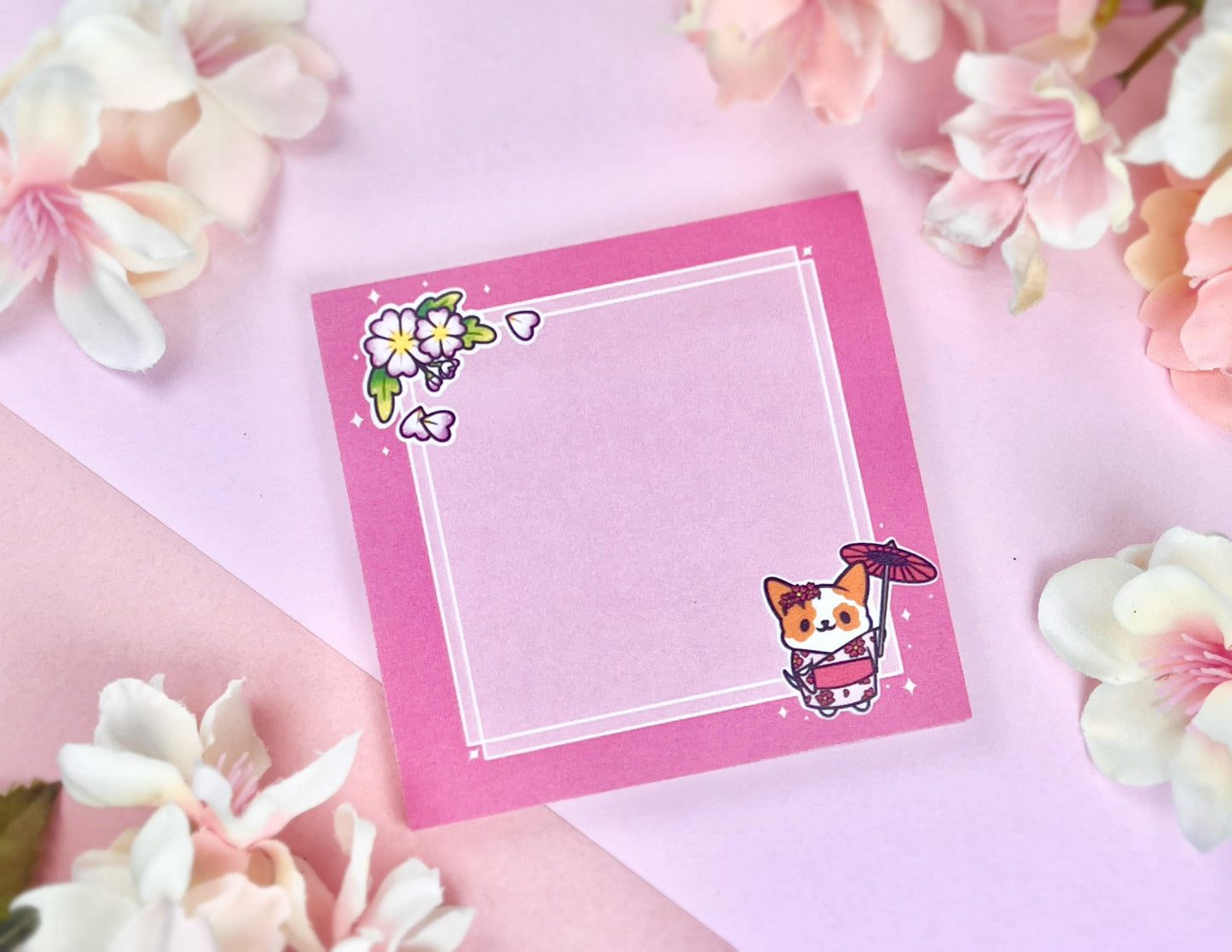 Pink sticky notes that have an illustration of a cute dog wearing a pink kimono holding an umbrella under cherry blossoms. 