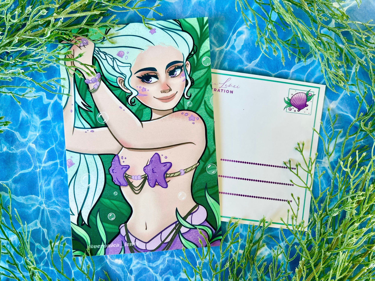 Beautiful mermaid putting her blue hair up and getting ready for her day among the seaweed.