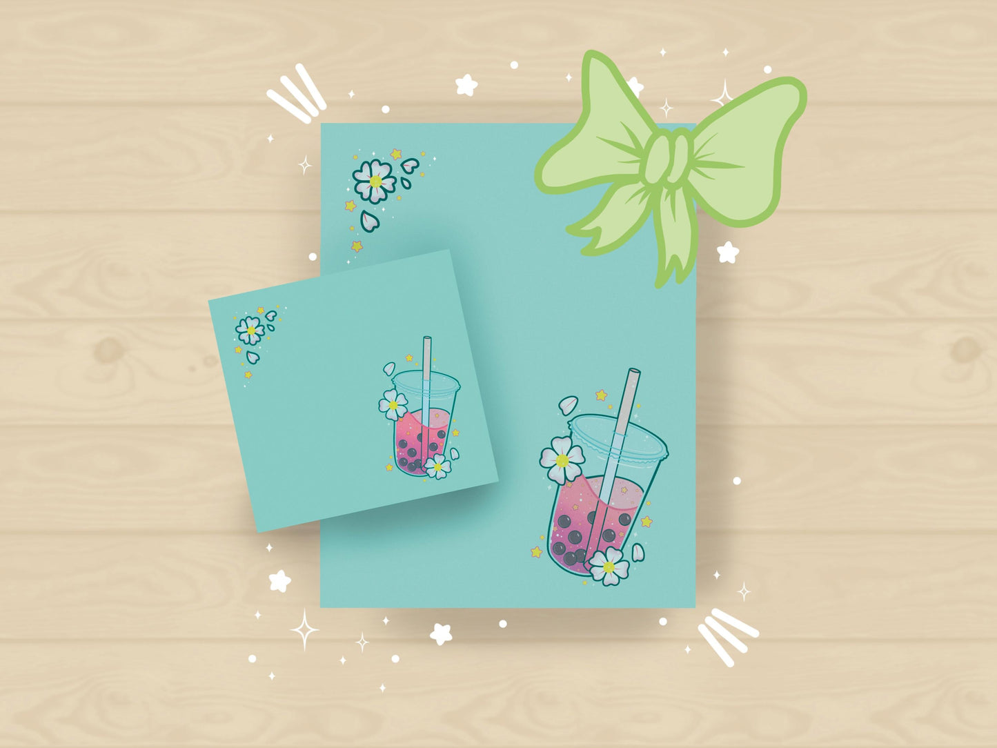 A light blue gift set including one sticky note and one notepad with an illustration of pink boba milk tea surrounded by pink flowers and yellow stars.