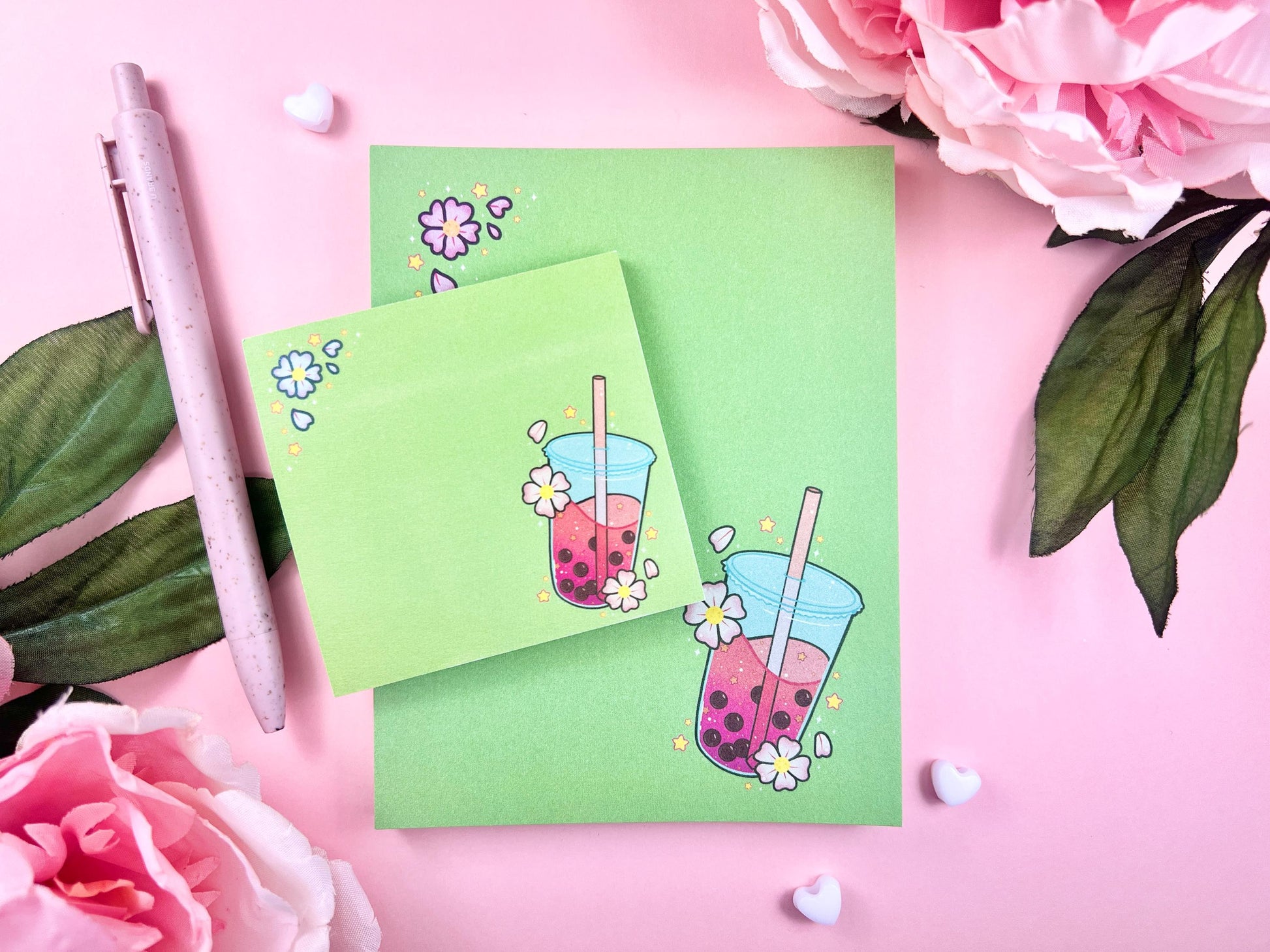 A green gift set including one sticky note and one notepad with an illustration of pink boba milk tea surrounded by pink flowers.