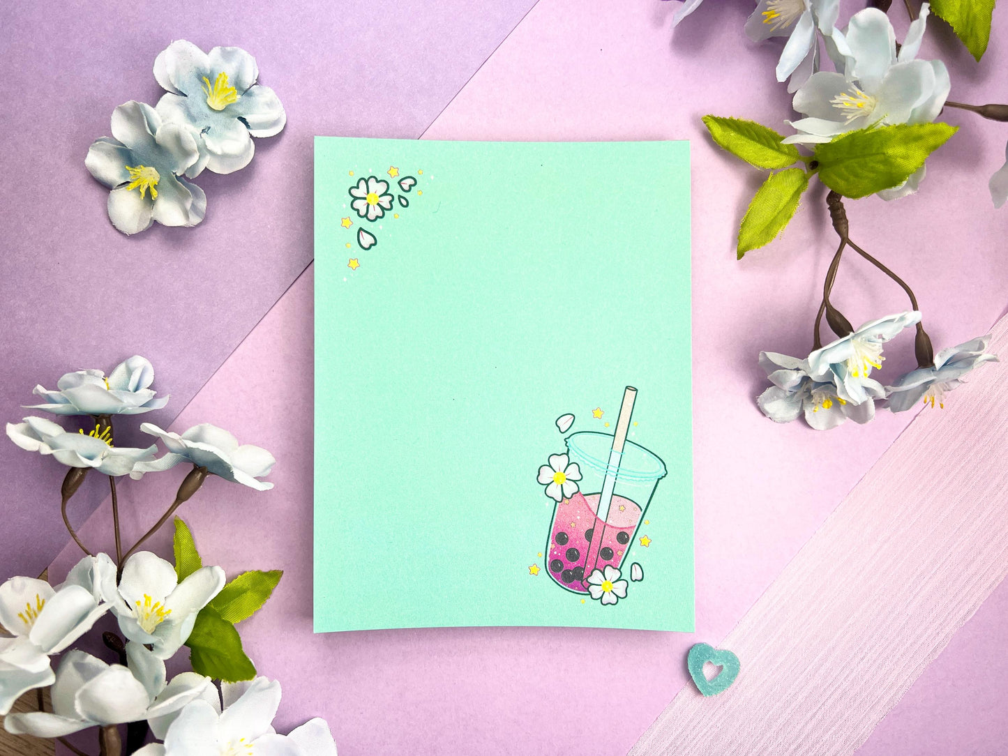 Light blue notepad with an illustration of pink boba milk tea surrounded by pink flowers.