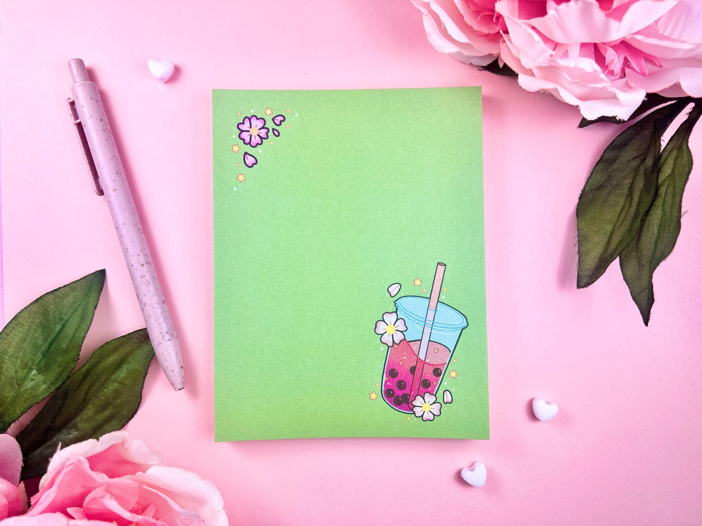 Green notepad with a pink boba milk tea illustration surrounded by pink flowers and yellow stars.