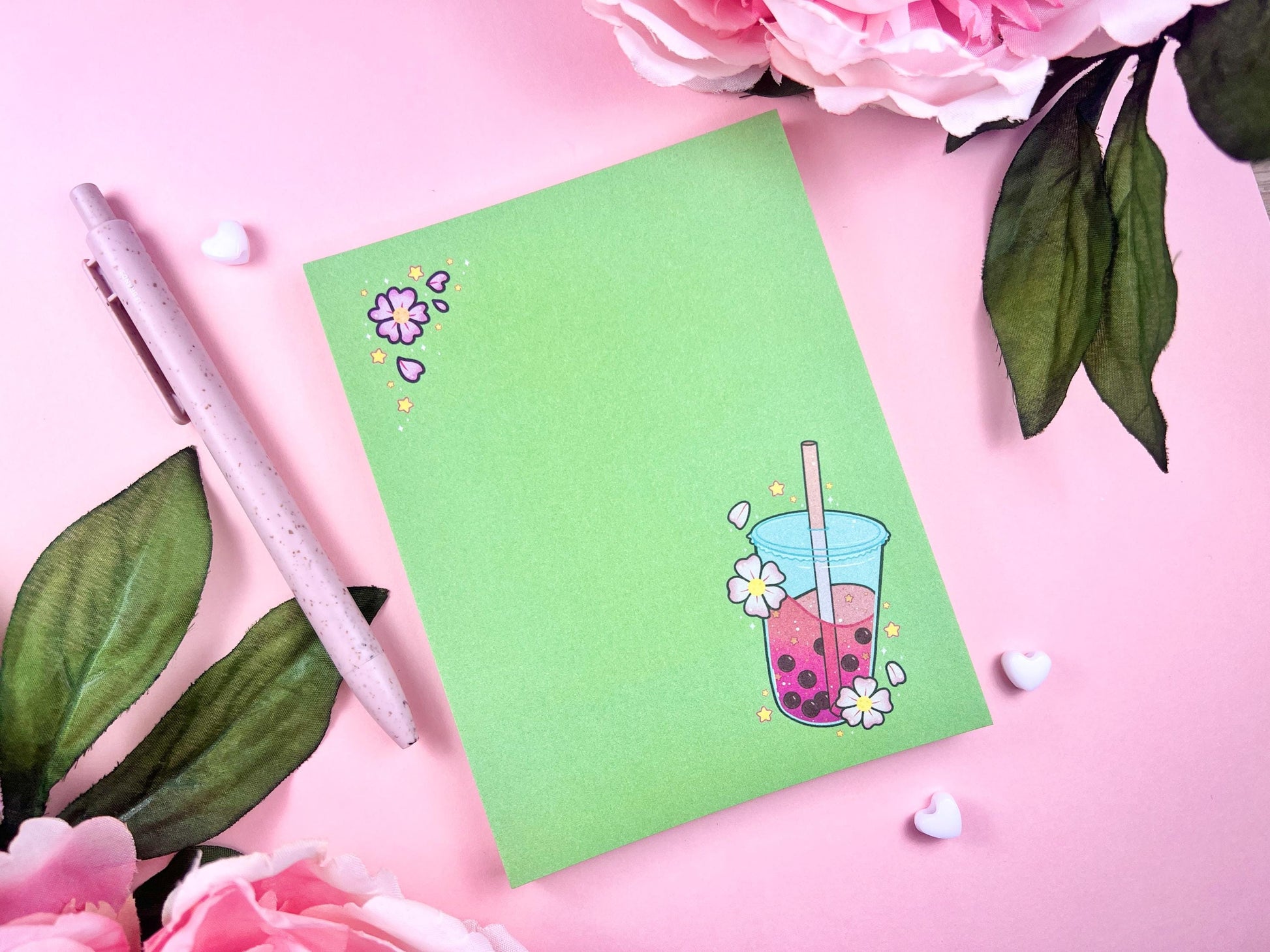 Green notepad with a pink boba milk tea illustration surrounded by pink flowers and yellow stars.