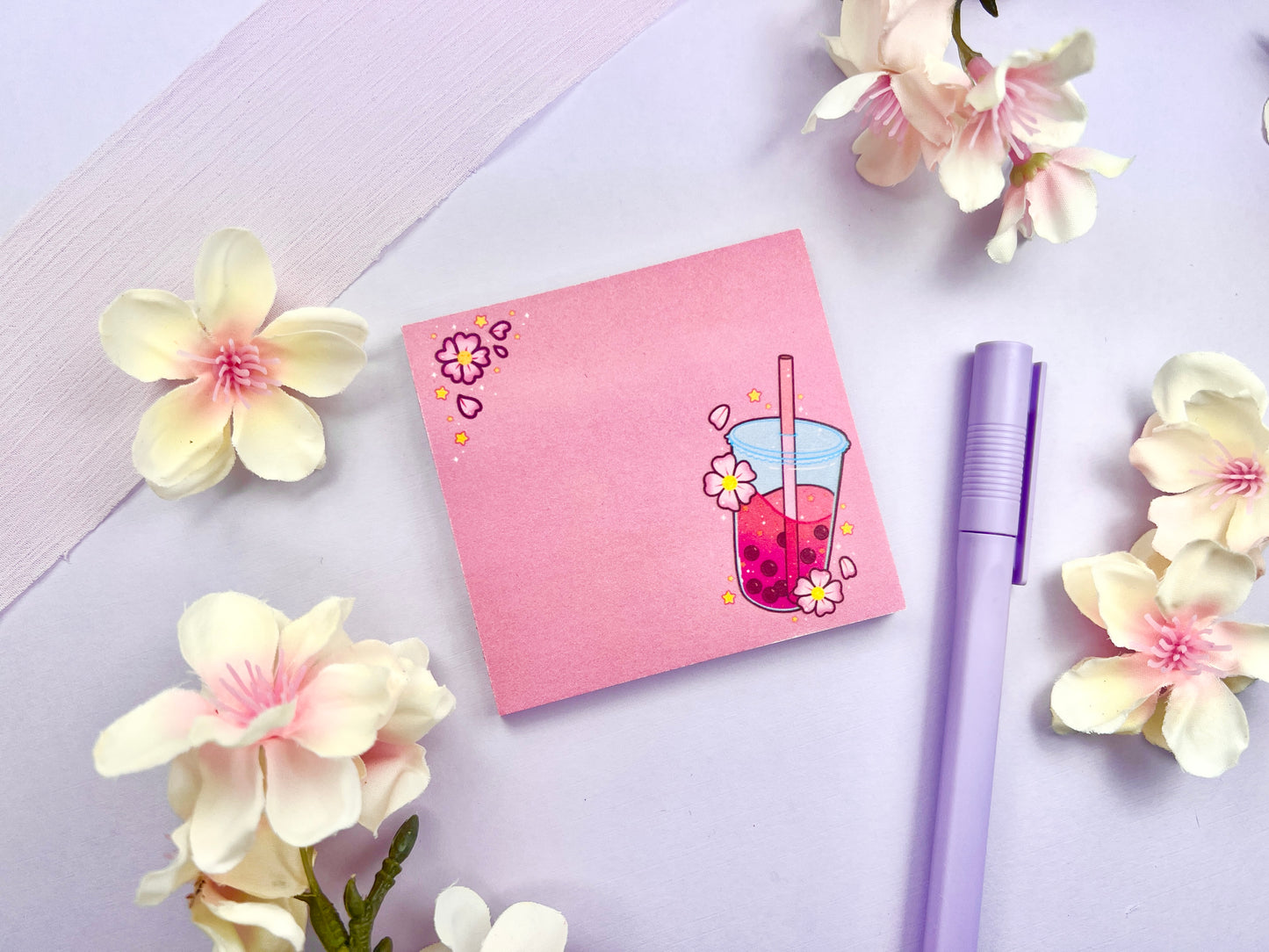 Pink sticky note with and illustration of pink boba milk tea surrounded by pink flowers and yellow stars.