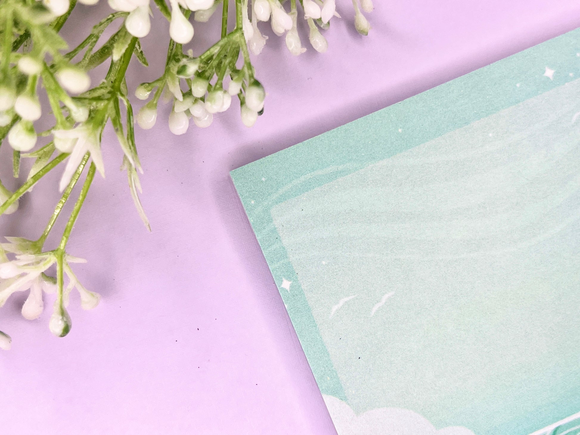 Green and white sticky notes with an illustration of an ocean below the clouds.