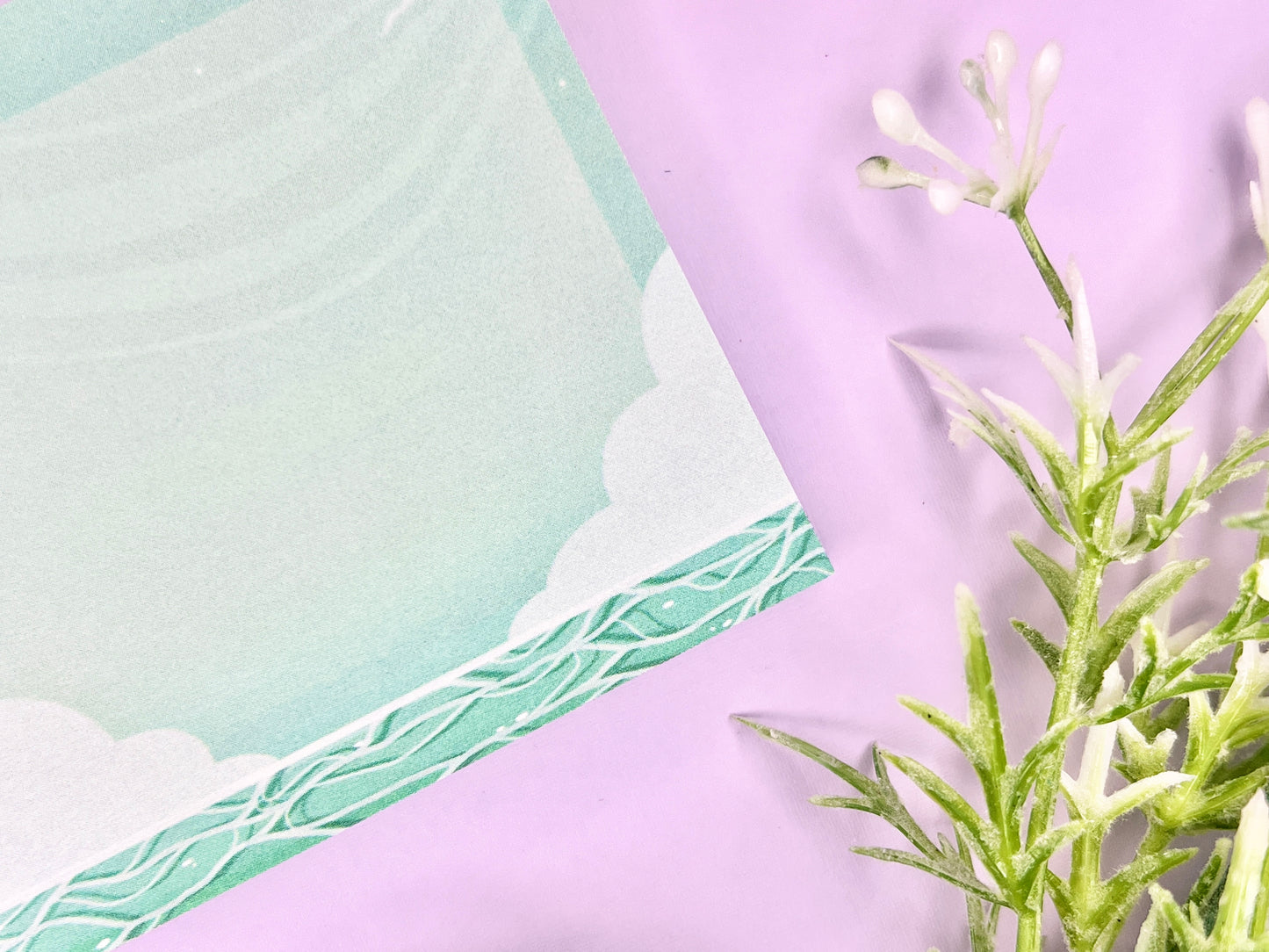 Green and white sticky notes with an illustration of an ocean below the clouds.