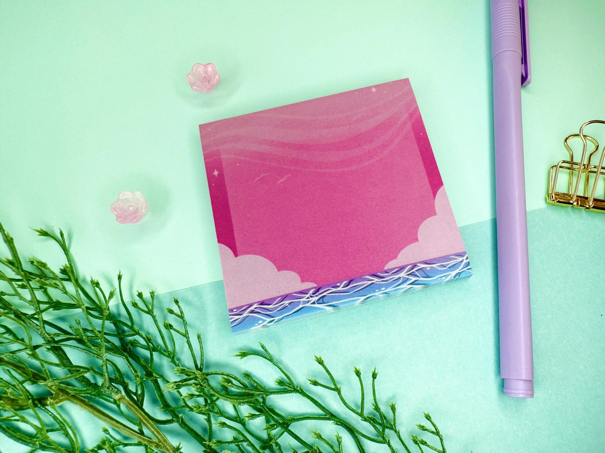 Pink and blue sticky notes with an illustration of an ocean below the sky and clouds.