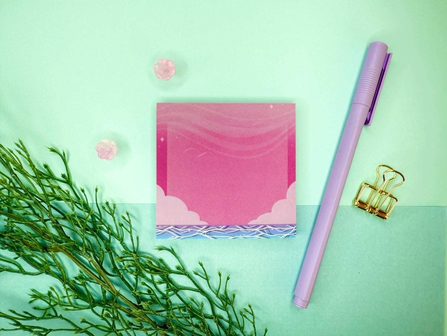 Pink and blue sticky notes with an illustration of an ocean below the sky and clouds.