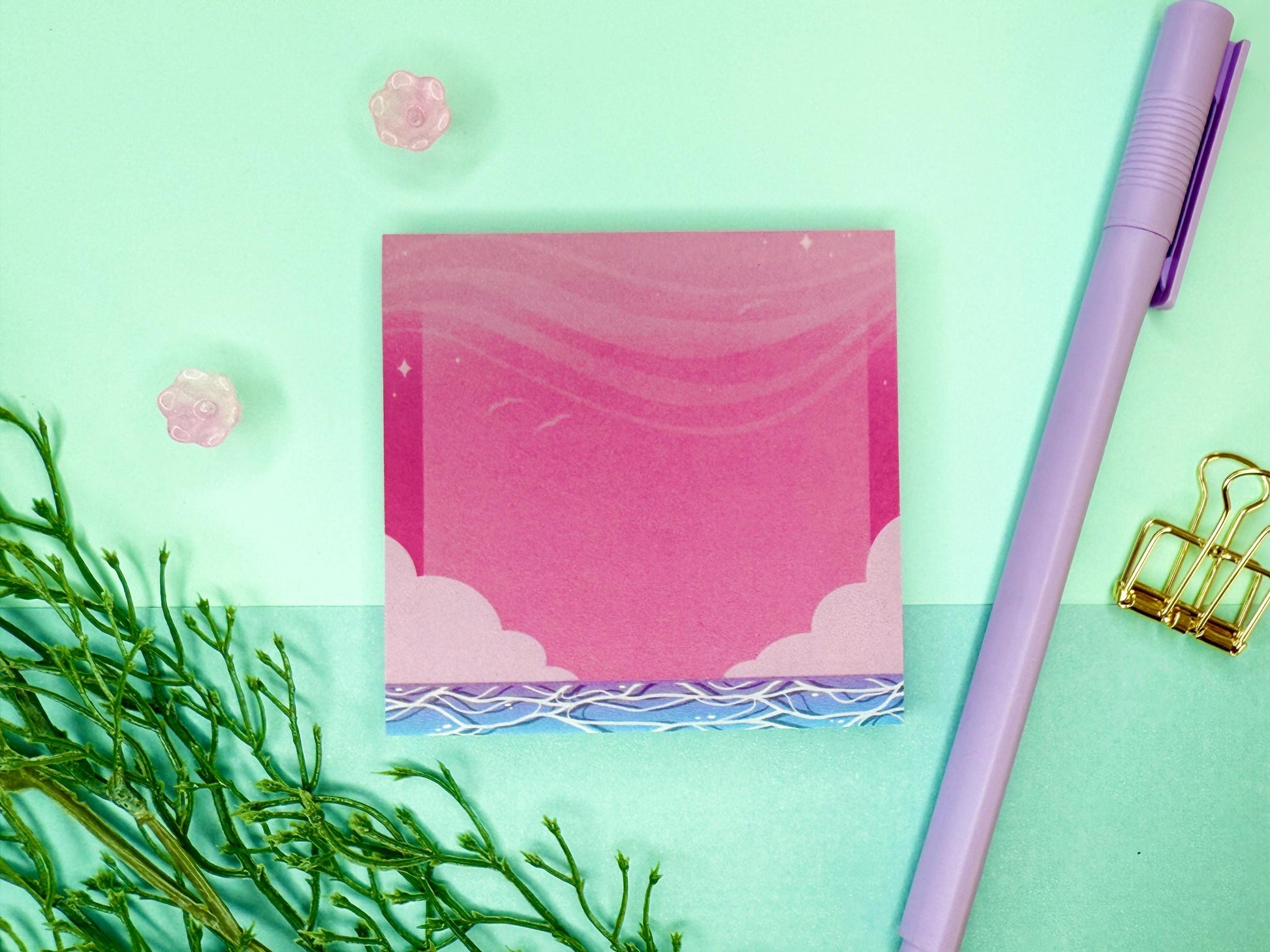 Pink and blue sticky notes with an illustration of an ocean below the sky and clouds.