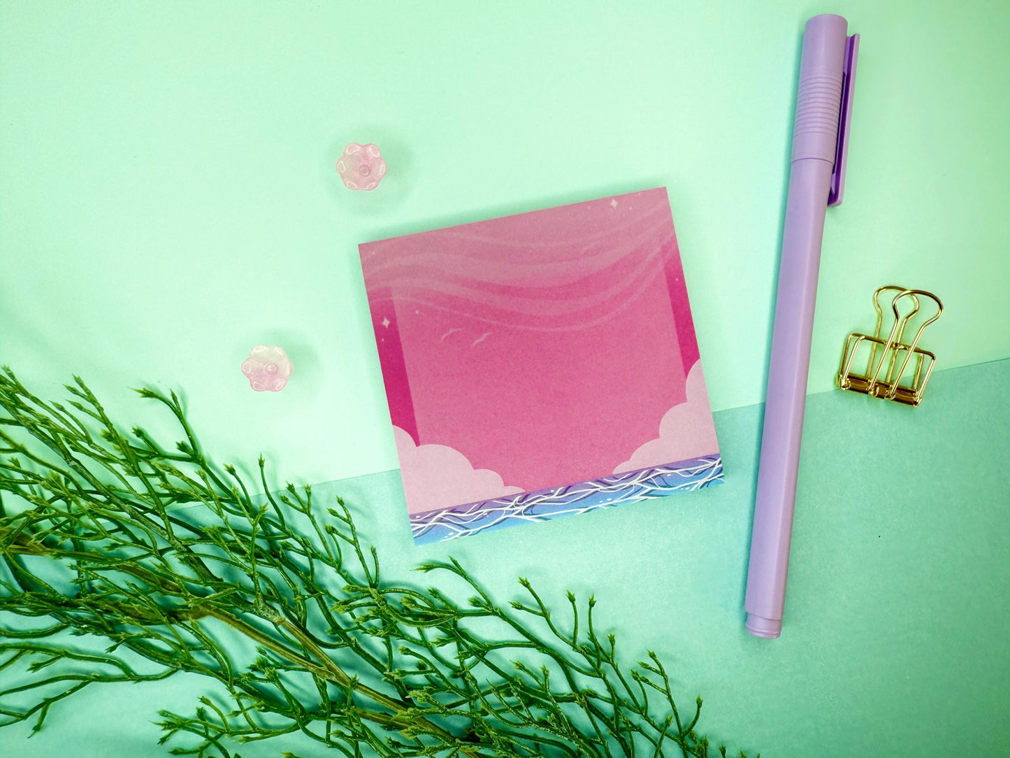 Pink and blue sticky notes with an illustration of an ocean below the sky and clouds.