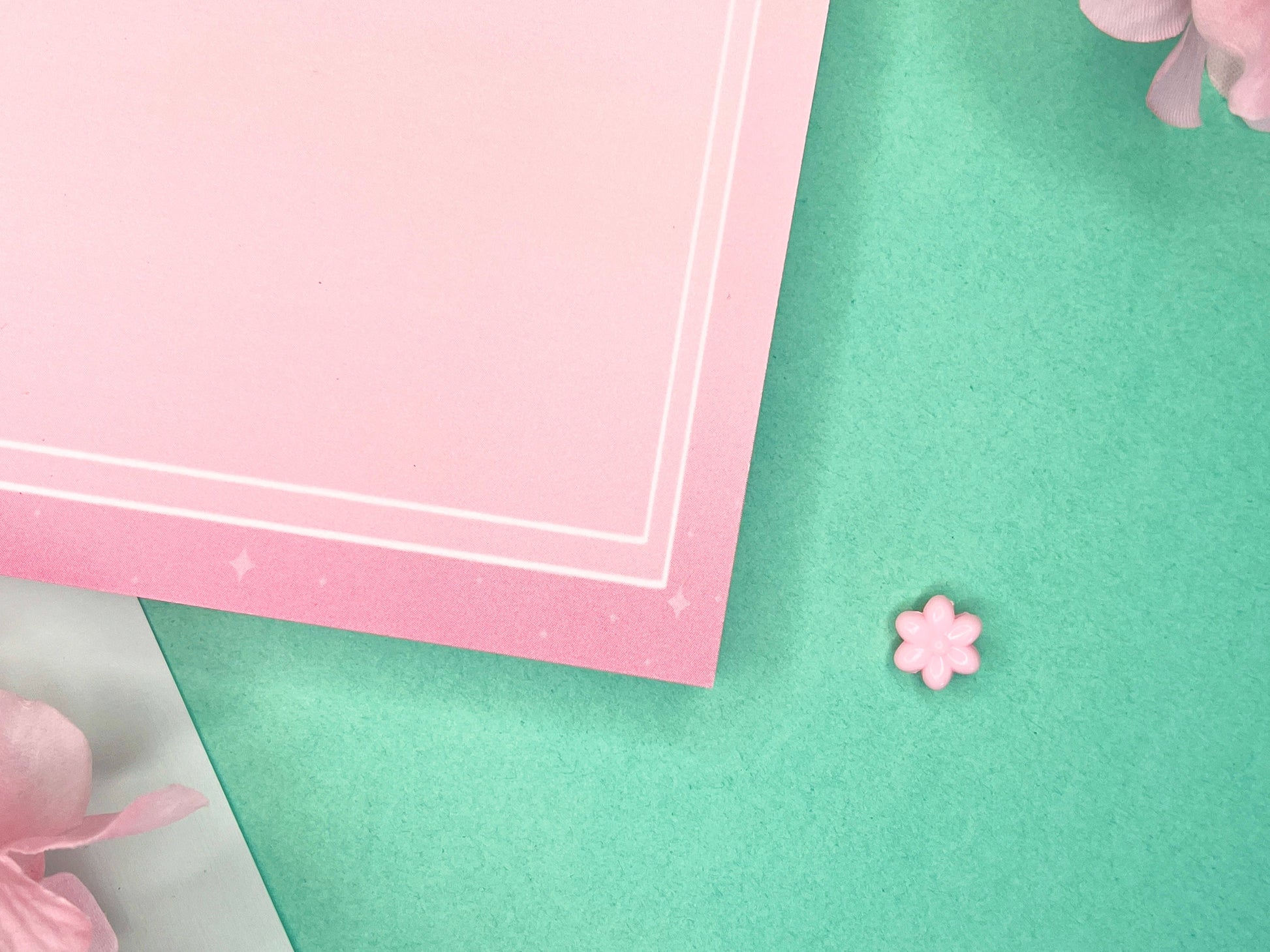 Pink notepad with pink hydrangea flowers bordering the top and a double white border inset from the sides and bottom.