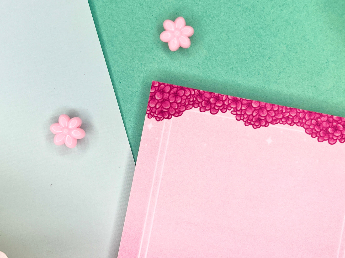Pink sticky notes with a border of pink hydrangeas at the top and white squares around the rest.
