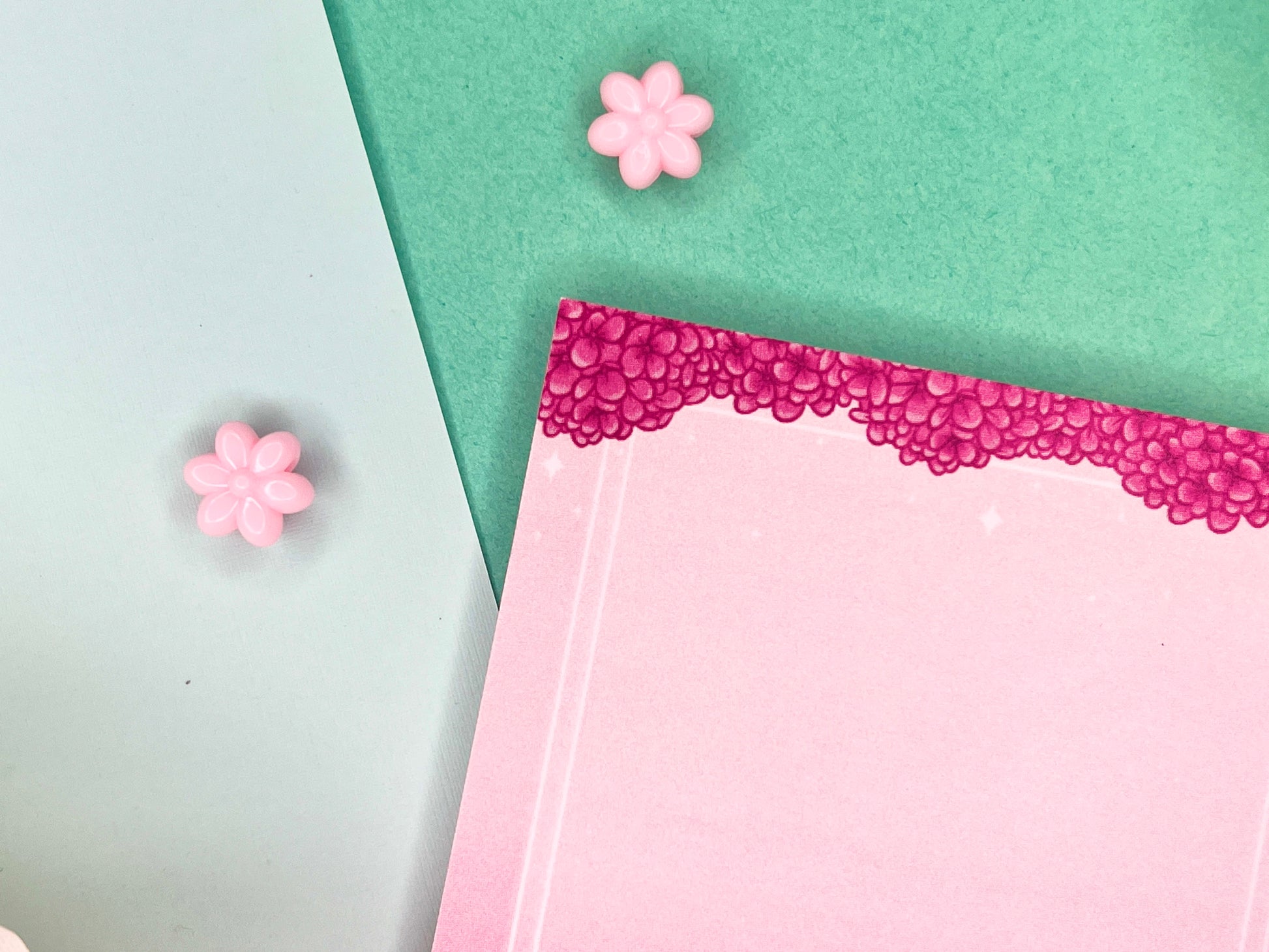 Pink sticky notes with a border of pink hydrangeas at the top and white squares around the rest.