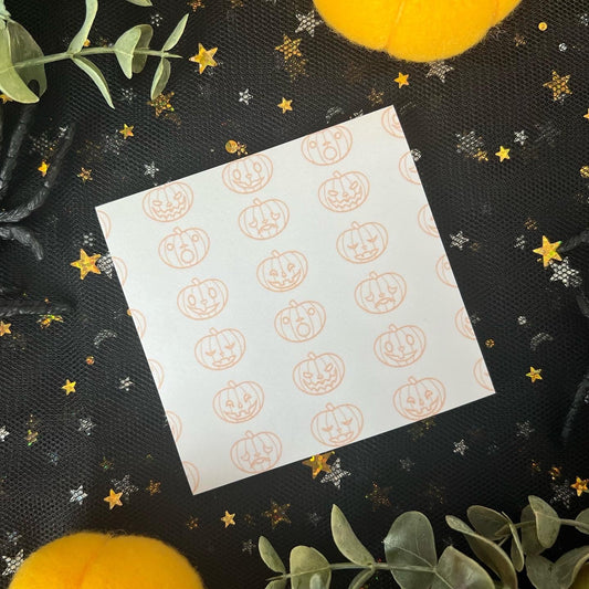 White sticky notes with orange pumpkins that have different styled faces.