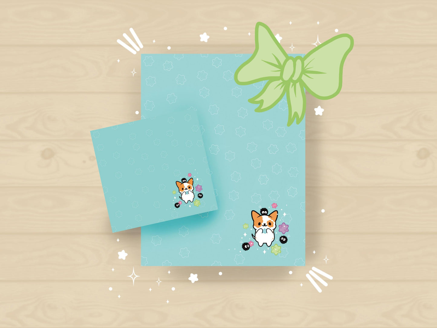 A blue gift set that includes one sticky note pad and one notepad with an illustration of a cute dog playing with soot sprites and rainbow konpieto and has a konpieto patterned background.