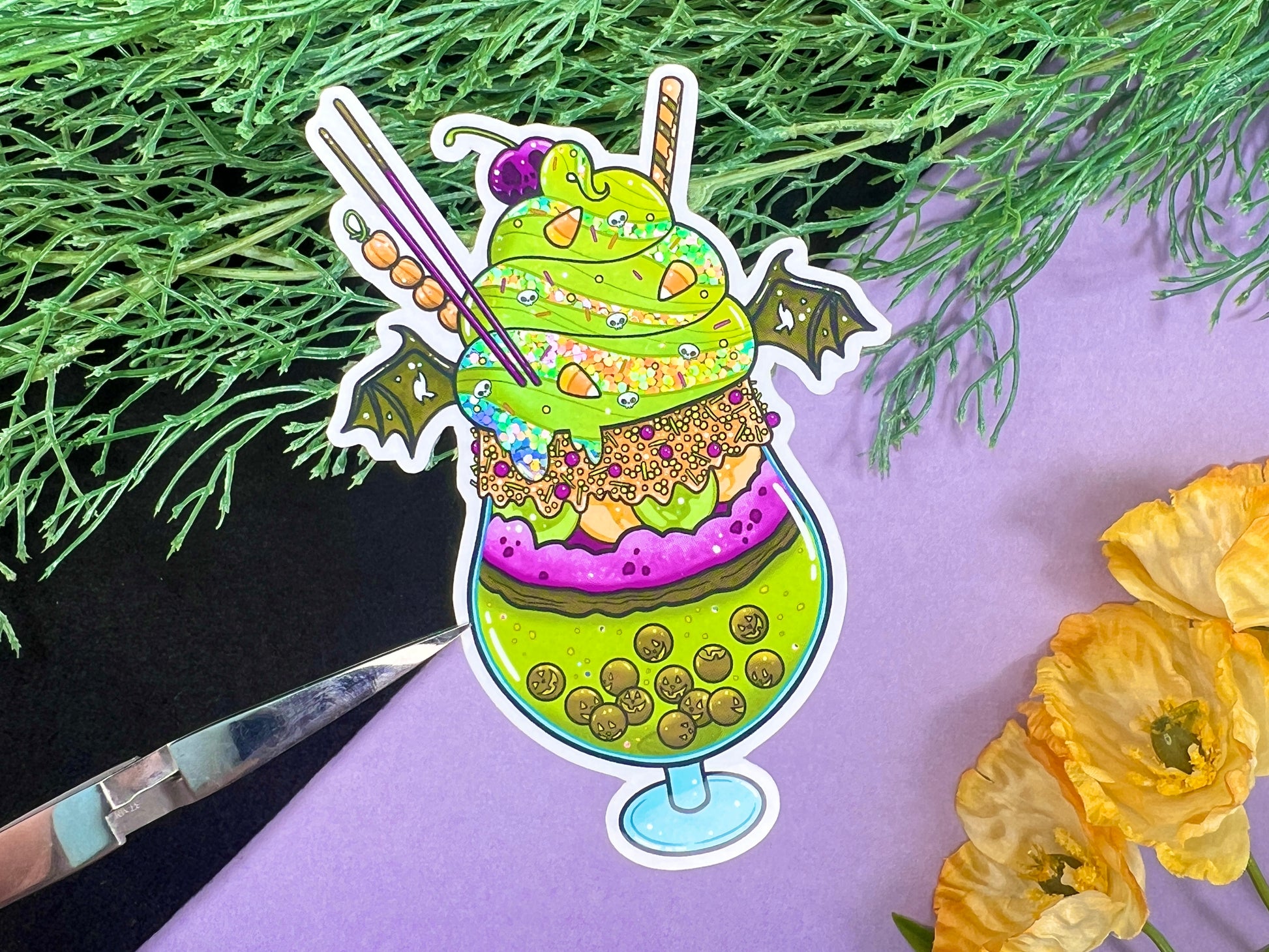 A green, orange, and purple sticker illustration of a spooky drink with jack o'lantern boba, frosting, sprinkles, whip cream, candy corn, a skull cherry, straw and bat wings.