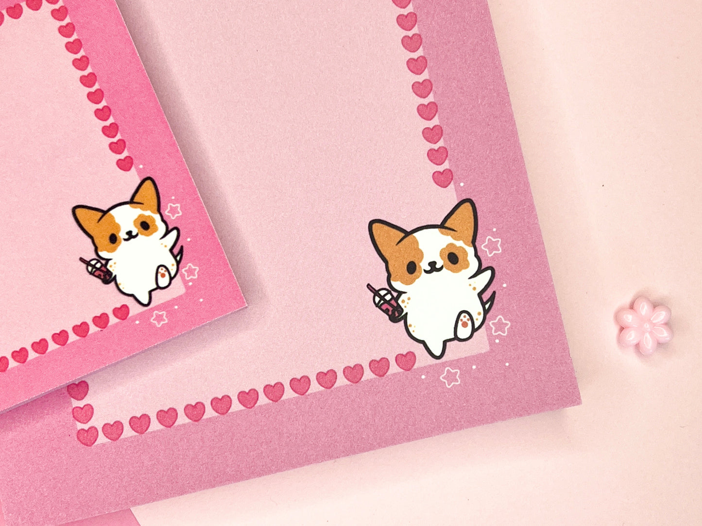 Pink gift set including one sticky note pad and one notepad with an illustration of a cute dog holding boba milk tea surrounded by hearts and strawberries.