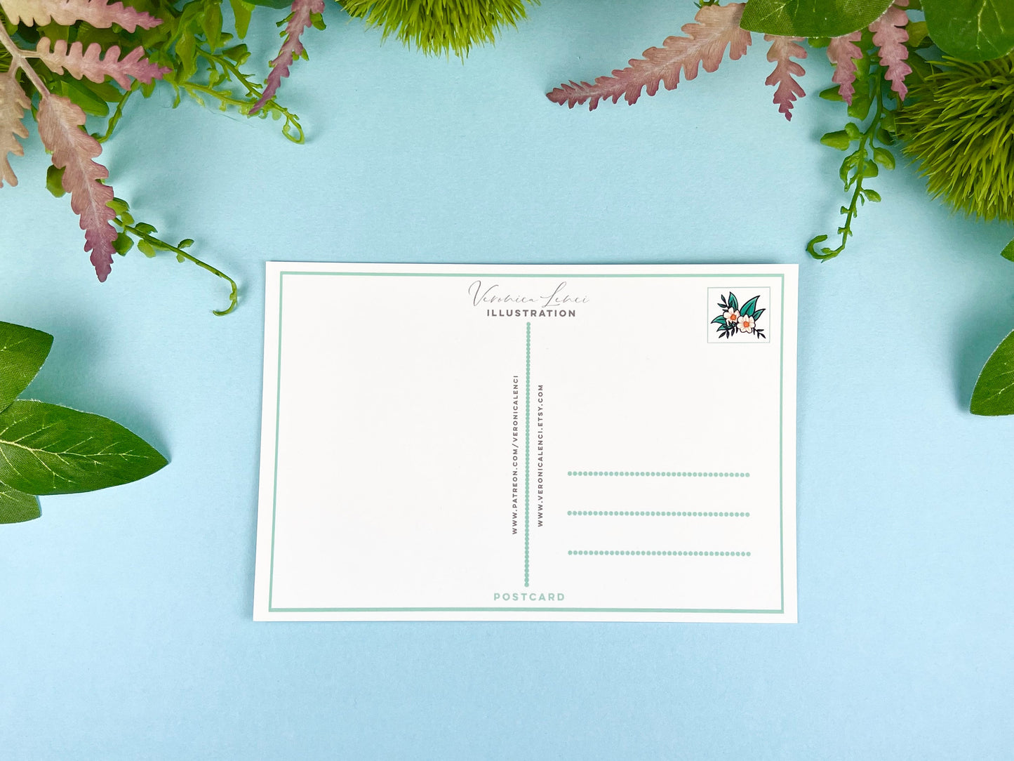 Back of the postcard with a line down the middle, lines on the right side for and address, and flowers where the stamp would go.